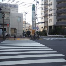 一つ目の信号を（本郷通り）を左に渡ります。 正面が三井住友銀行です。銀行と高層マンションの間の道を直進してください。 