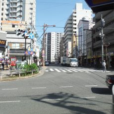 横断歩道を渡り、100円STOREを左手に見ながらそのまま直進すると、正面左手に三井住友銀行見えてきます。 そのまま三井住友銀行と高層マンションの間の道を直進してください。 